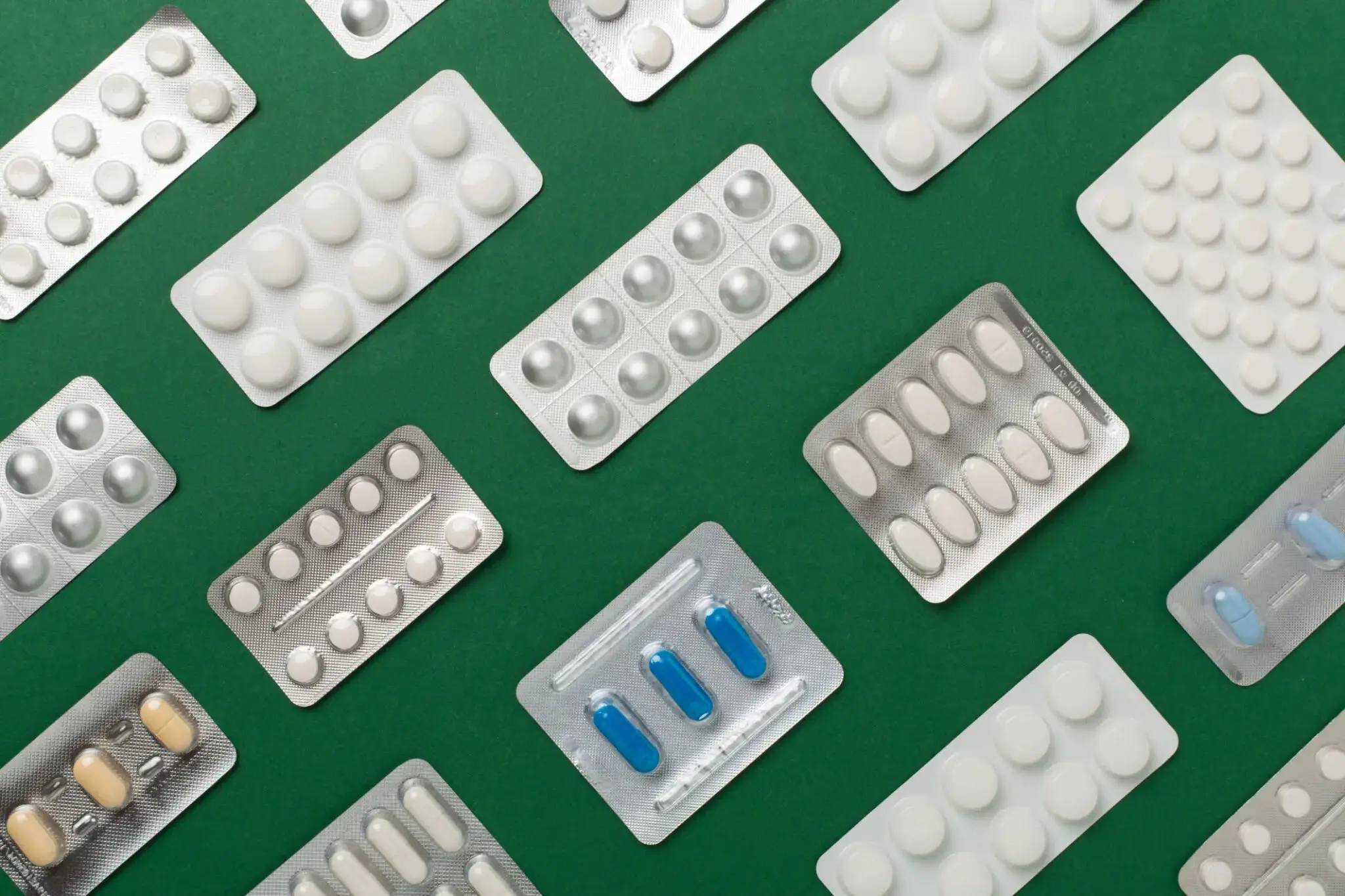 image A green table topped with lots of white pills.